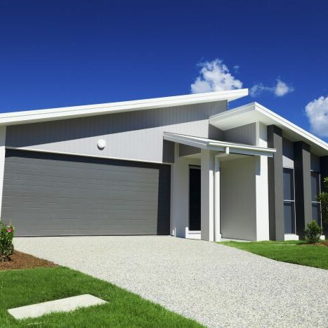 New suburban Australian house with small SOLD sign.