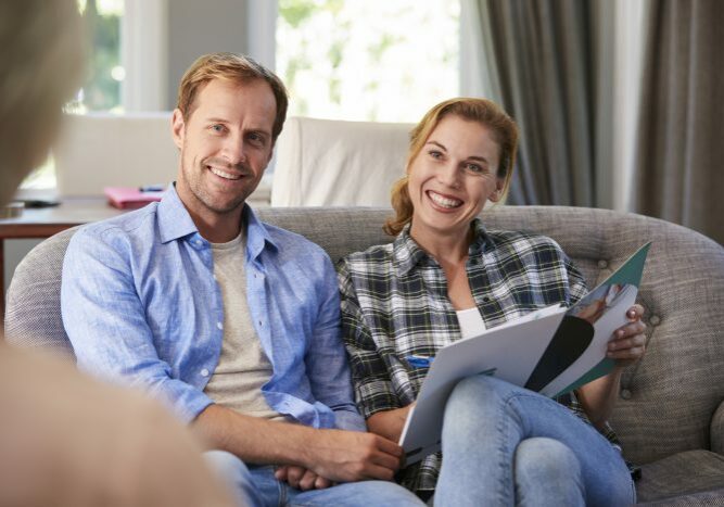 Happy young couple taking financial advice at home